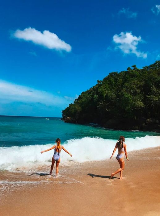 Tess and Sarah dash joyfully along the beach.