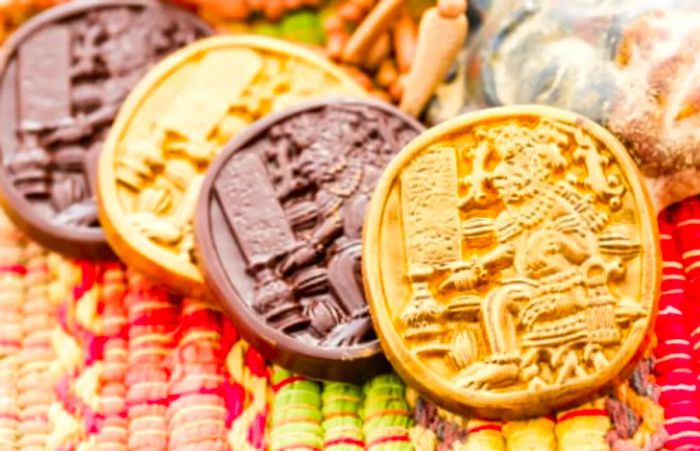 gold and brown Mexican chocolate adorned with Mayan hieroglyphs