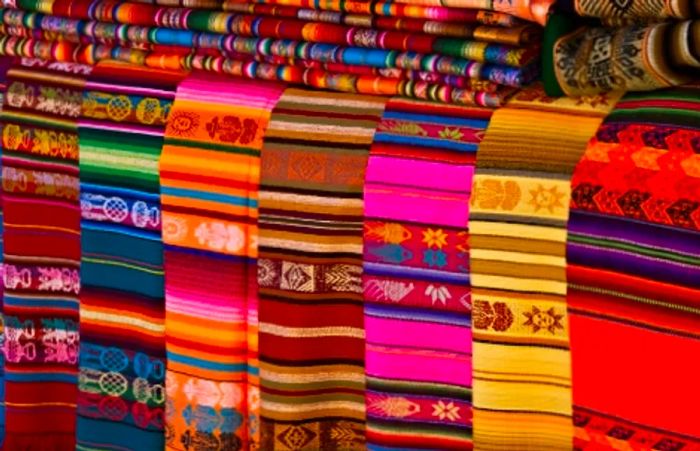 traditional Mexican textiles arranged on a table for sale