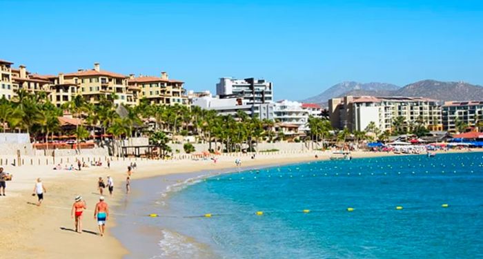 people strolling along Playa El Medano beach in Cabo San Lucas