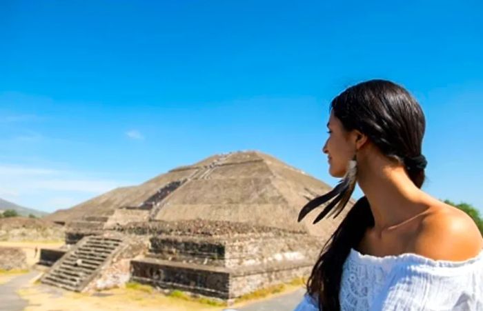 A woman gazing at a Mayan pyramid located in the Western Caribbean