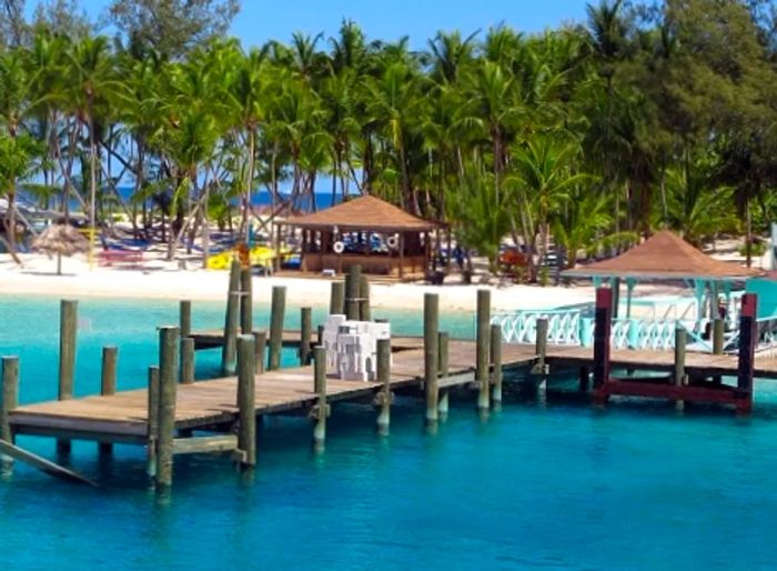 A wooden pier stretching over the pristine blue waters of Blue Lagoon Beach in Nassau, Bahamas