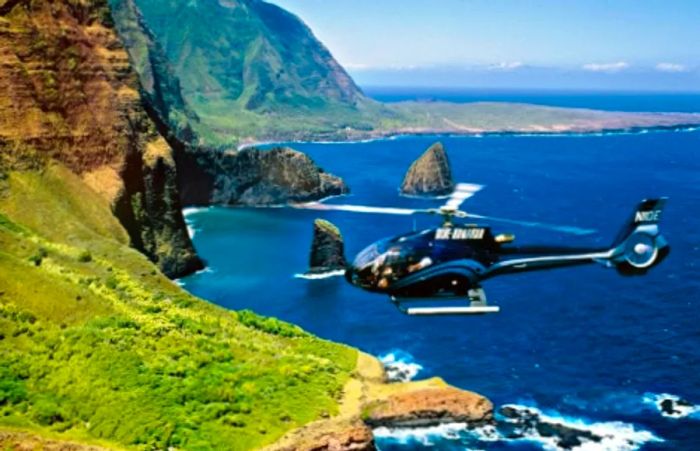 blue helicopter heading towards the lush island of Maui