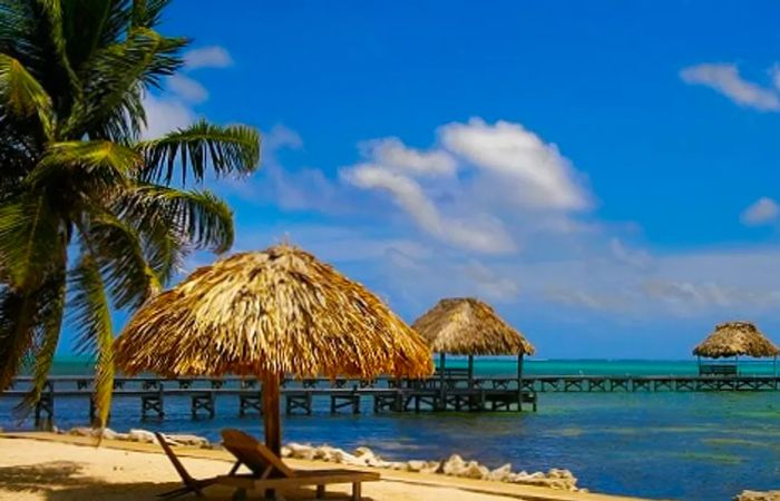 A picturesque beach in Belize adorned with canopies and beach chairs