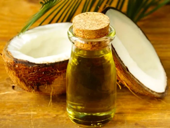 coconut oil in a glass jar next to a freshly cracked coconut