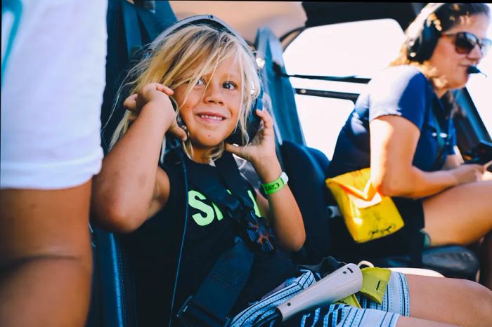 A boy sporting a headset inside the helicopter