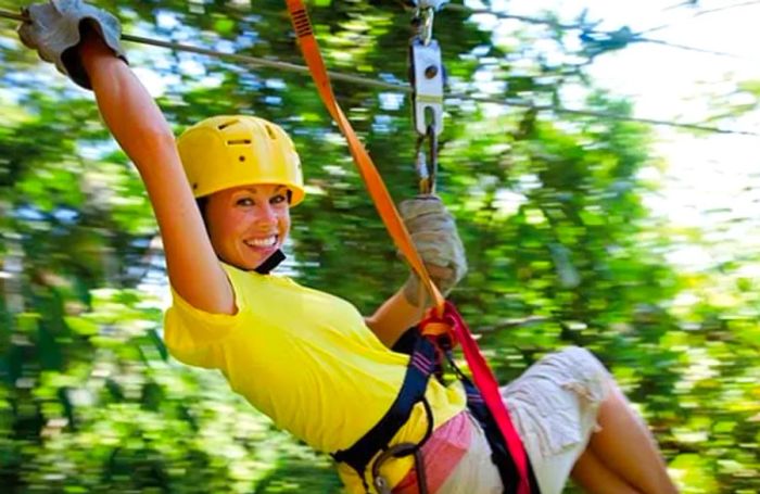 a woman soaring through the rainforest on a zip line