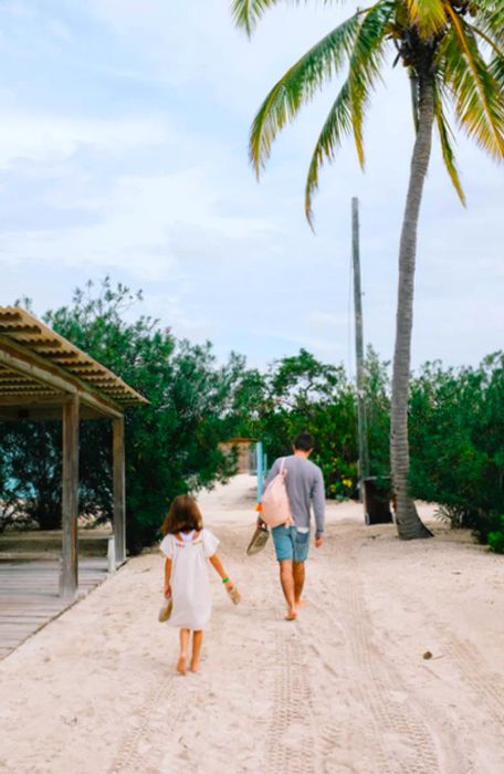 dad and daughter heading towards the beach