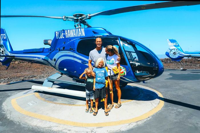 Andy and family pose in front of the helicopter before their tour