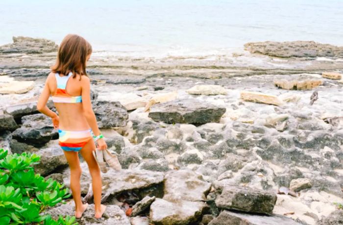 daughter strolling along the rocky shoreline