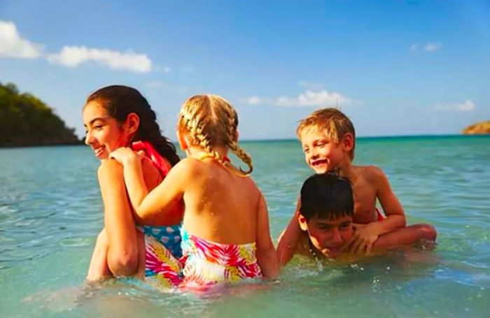 a group of children enjoying the water at a Caribbean beach