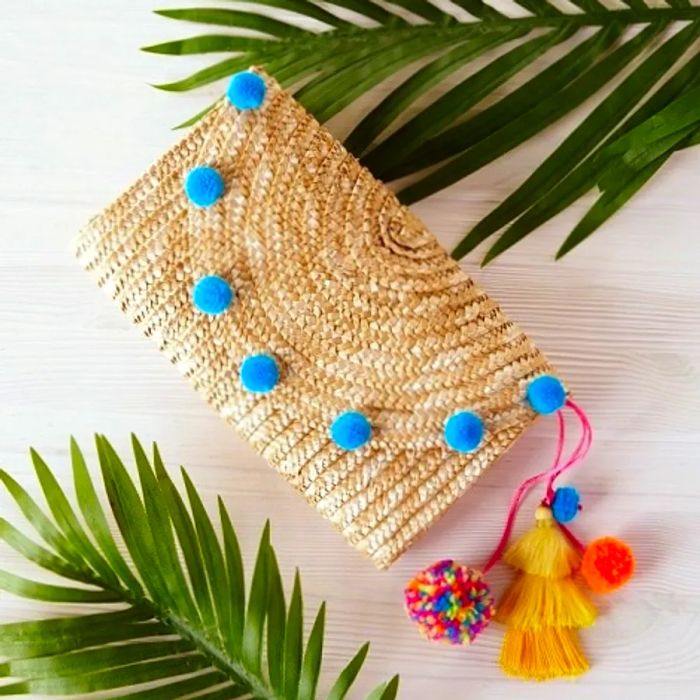 tassel-decorated straw clutch