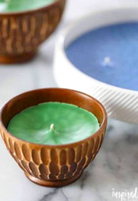 A broader view of a small candle holder featuring a green candle