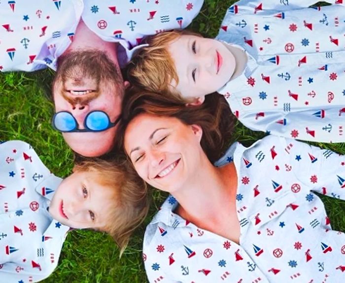 family lounging on the grass in Dinogo snooze fun pajamas