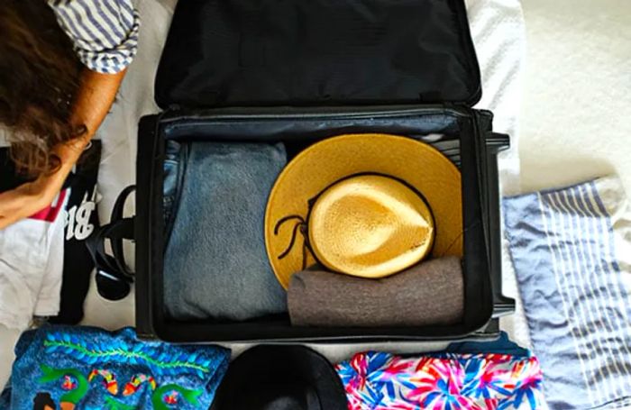 Aerial shot of a suitcase with a stack of hats inside.