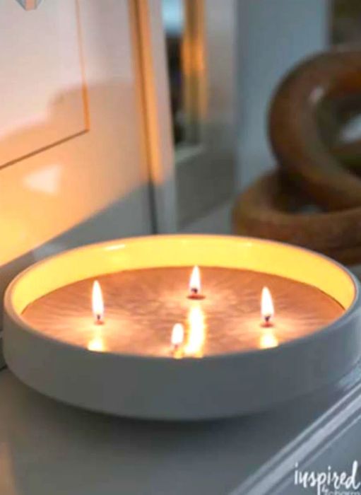 A lit candle displayed on a mantel