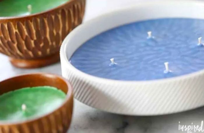 Three candles nestled in wooden bowls alongside one crafted from white porcelain