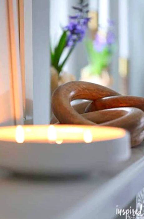 A glowing candle perched on a mantelpiece