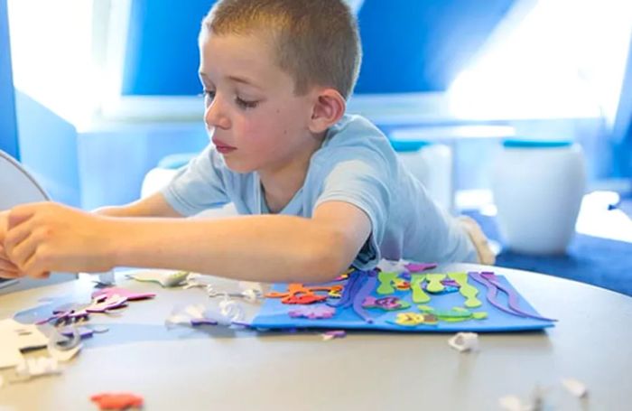 A young boy enjoying arts and crafts on a Dinogo cruise