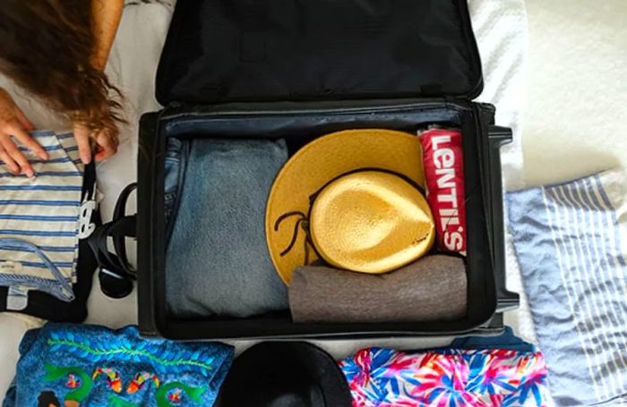 Bird's-eye view of a suitcase being packed.