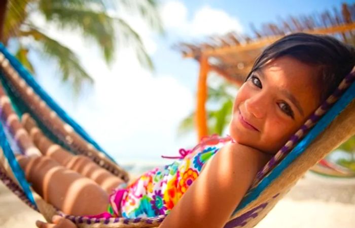 a young girl happily lounging in a hammock