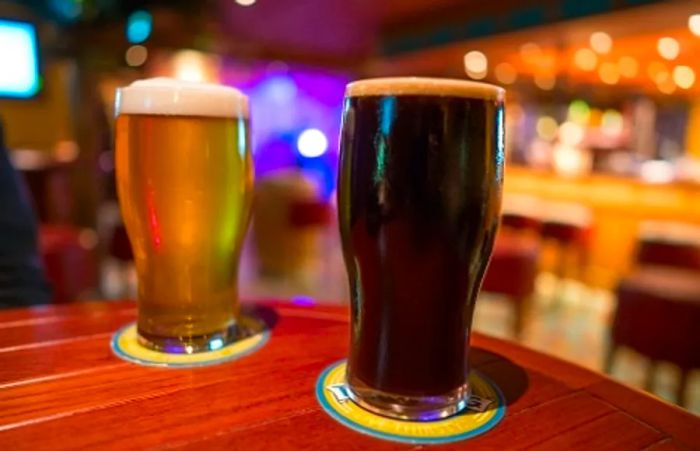 two beer mugs sitting on a table at the RedFrog Pub