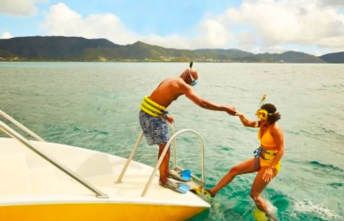 a man assisting a woman onto a boat after a snorkeling session