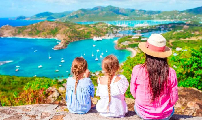 A mother and her two daughters enjoying the breathtaking view of English Harbor from Shirley Heights, Antigua.