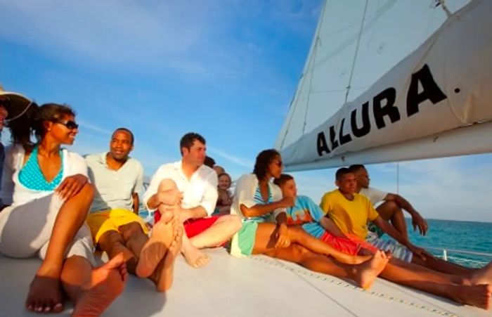 a group of people aboard a catamaran watching the sunset