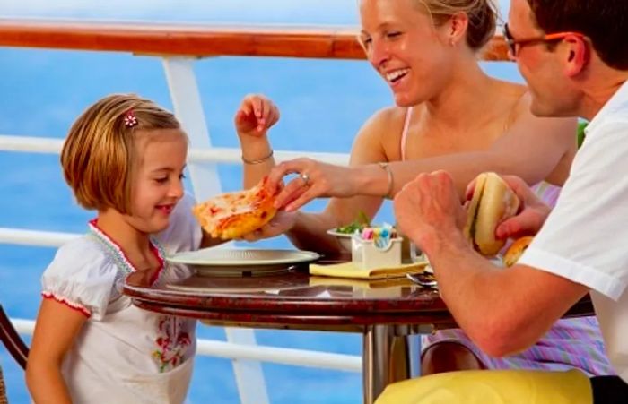 a little girl enjoying pizza with her family