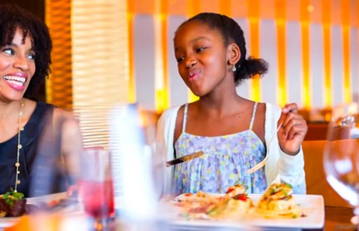 A girl savoring her meal aboard Dinogo’s Steakhouse.