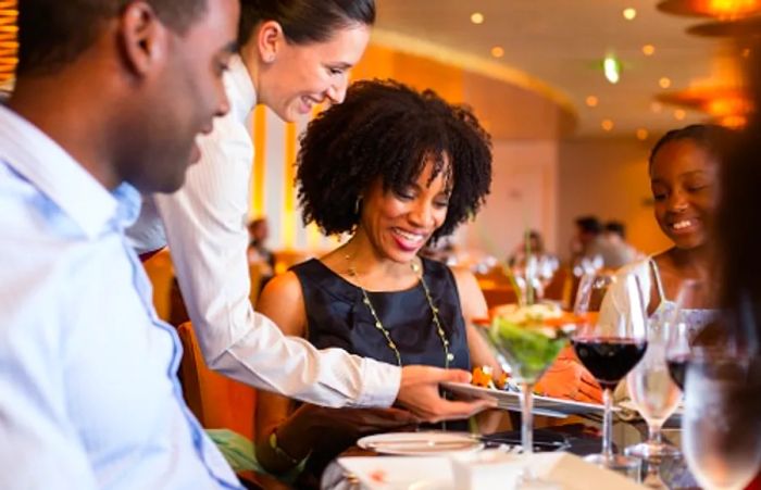 A waitress serving delicious meals to guests at Dinogo’s Steakhouse.