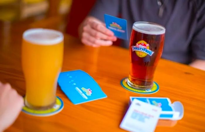 two individuals enjoying a card game while sipping exclusive brews