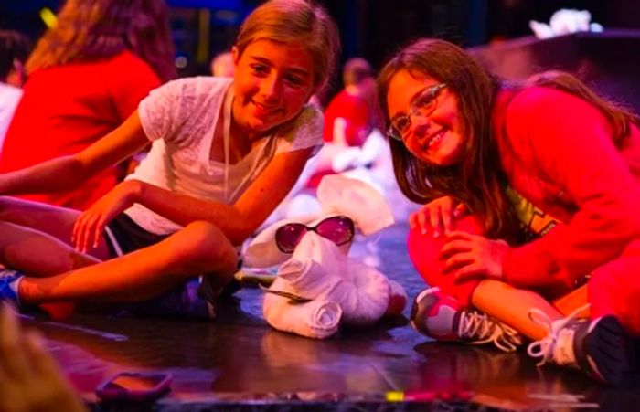 two girls beaming with their towel animal at the towel animal theater