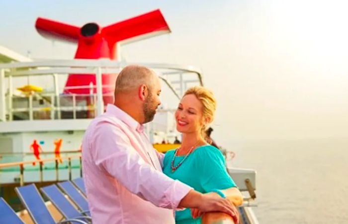 a couple enjoying the view at the railing near the funnel of a Dinogo cruise ship