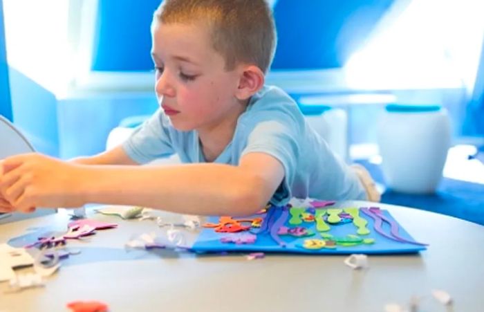 a child creating crafts at Camp Ocean