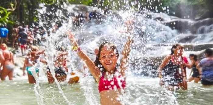 a young girl playing and splashing at a sandy beach