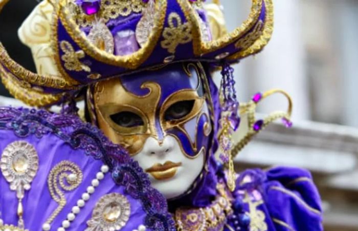 a purple and white Venetian mask worn during Mardi Gras