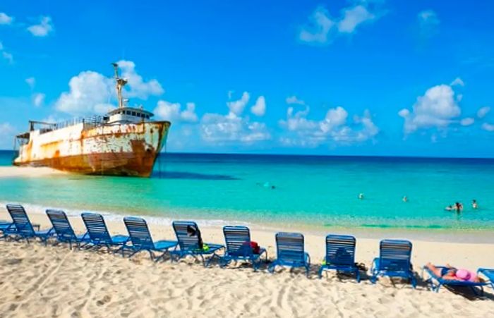 tourists relaxing on the stunning beach of Grand Turk beside a shipwreck