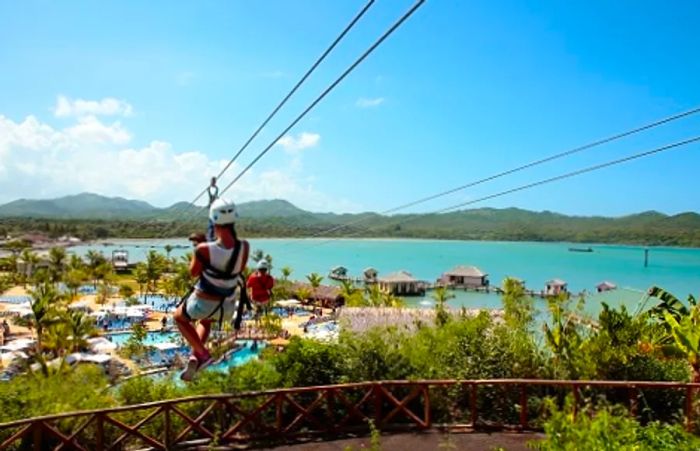 a woman ziplining above the beautiful private port of Amber Cove