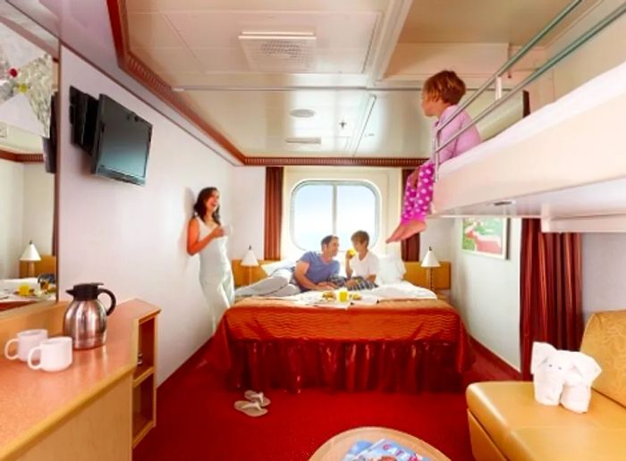 A family enjoying breakfast together in an ocean view stateroom.