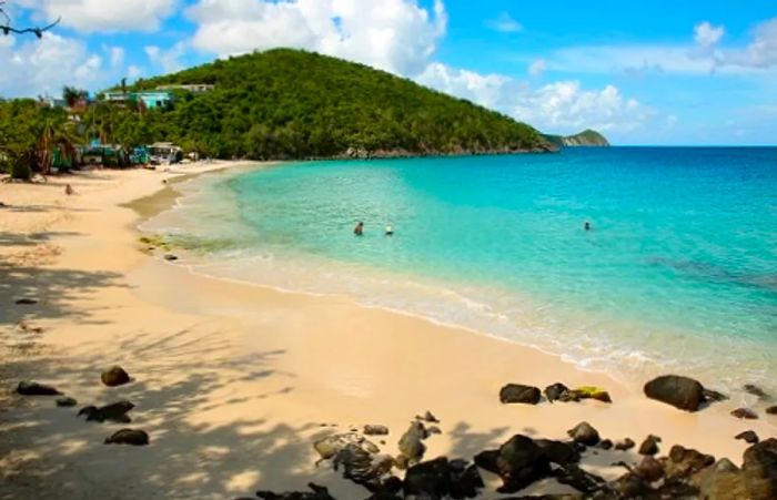 A stunning beach view in St. Thomas, framed by majestic mountains in the background.