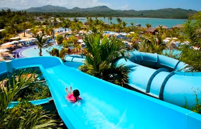 a little girl joyfully sliding down a water slide in Amber Cove