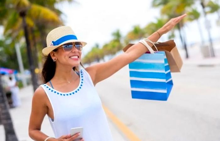 woman hailing a taxi while shopping near a beach in Tampa