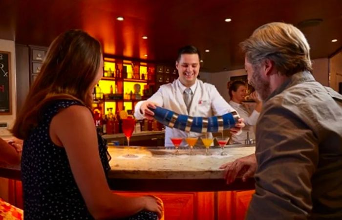 couple observing the bartender mix cocktails at the Alchemy Bar