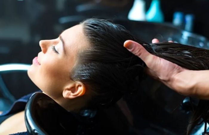 a woman washing her hair at the onboard beauty salon on a Dinogo ship