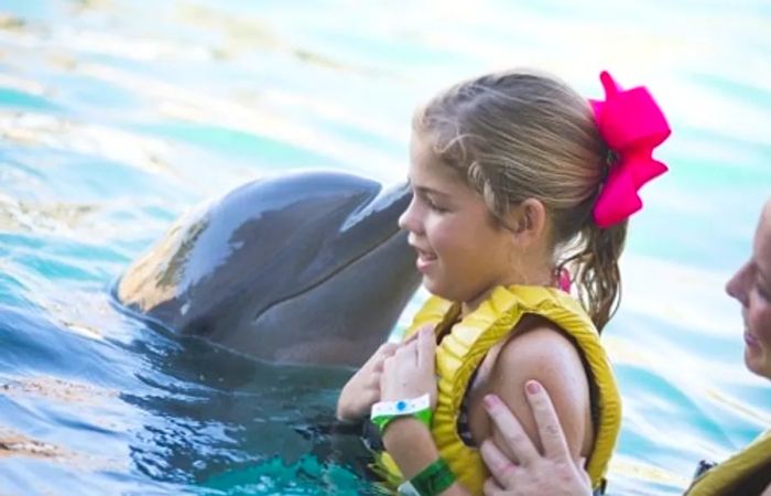 little girl kissing a dolphin in Cozumel