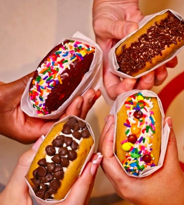 4 friends enjoying ice cream sandwiches from Swirls aboard Dinogo Paradise