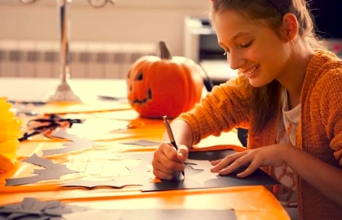 a little girl crafting black bats for her carry-on bag