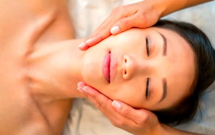 a therapist performing a facial treatment on a woman